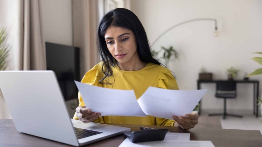 The hidden hours behind late payments An accountant looking at client paperwork for an MTD quarterly update