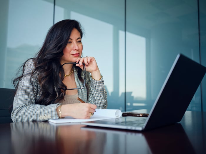 Solana Is Taking Active Steps to Reduce Its Coin Supply. But Is It Enough to Send SOL Soaring Higher? An investor sitting at a desk ponders a laptop while writing into a notebook.