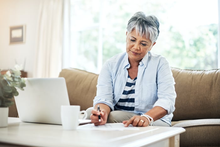 What Every 60-Year-Old Should Know About Social Security Person sitting at table looking at document.